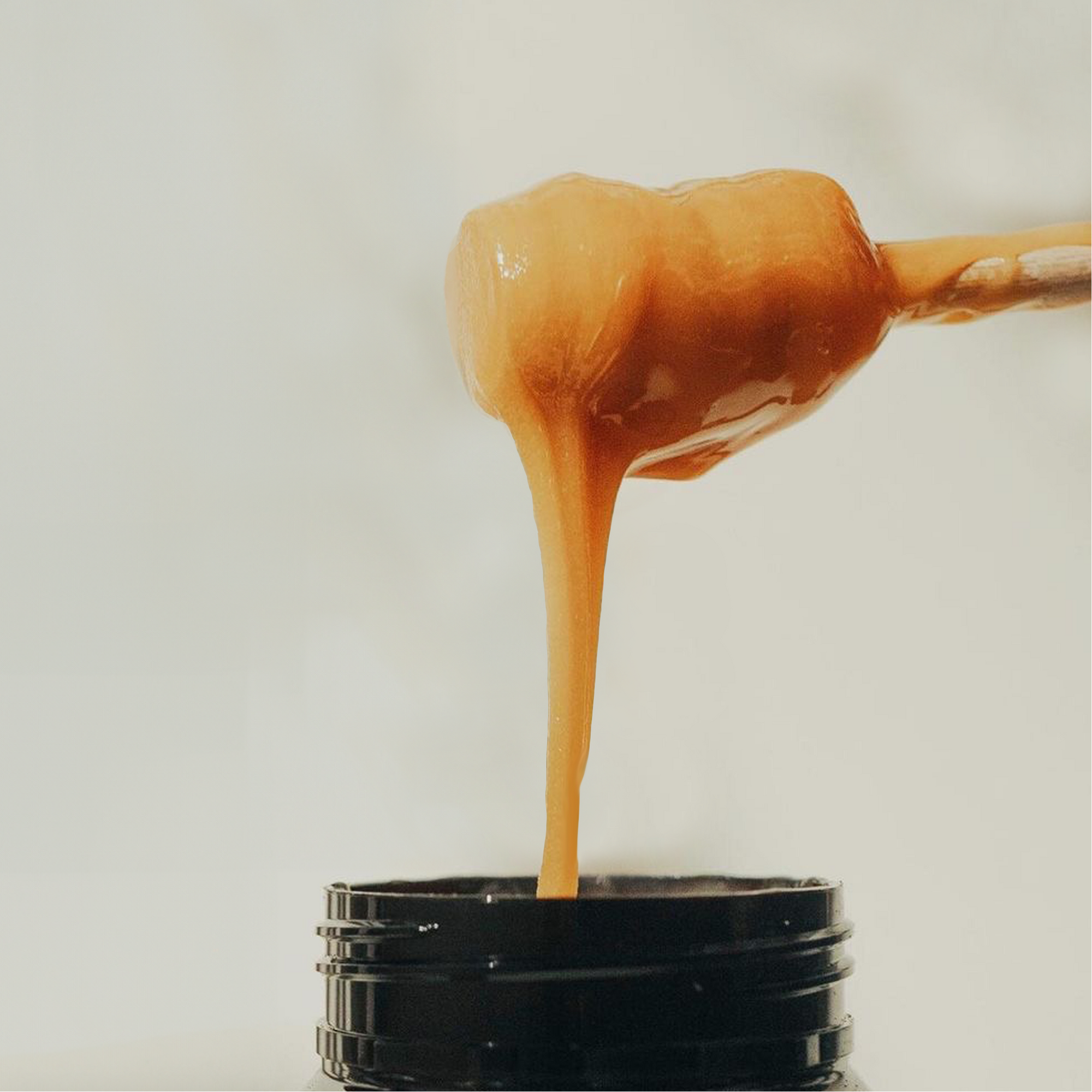 Manuka honey being drizzled from jar